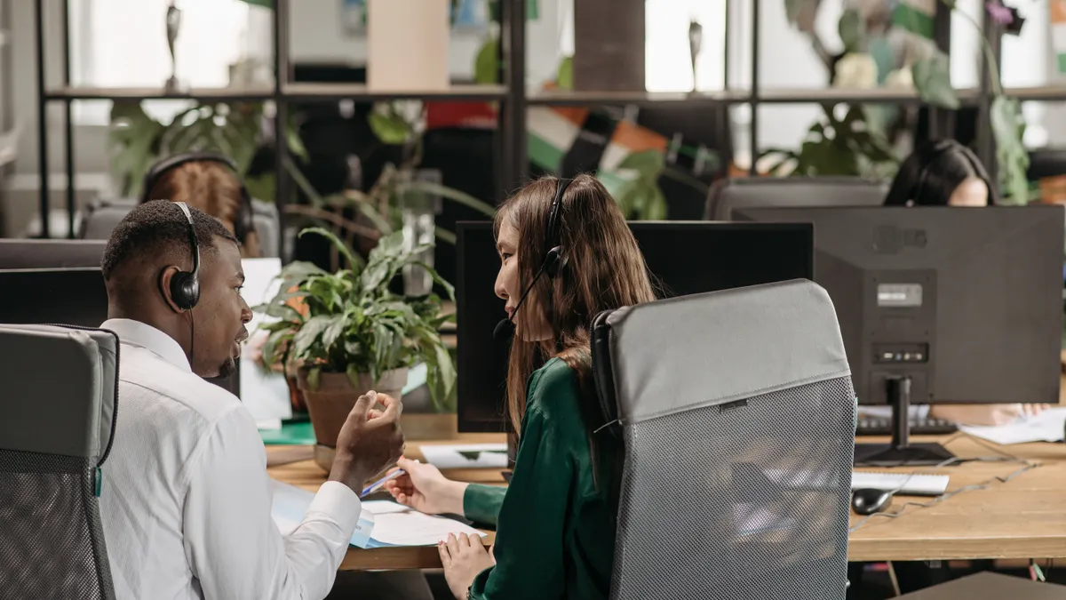 AI writing SaaS support options — The Complete Guide customer support agents talking in an open office